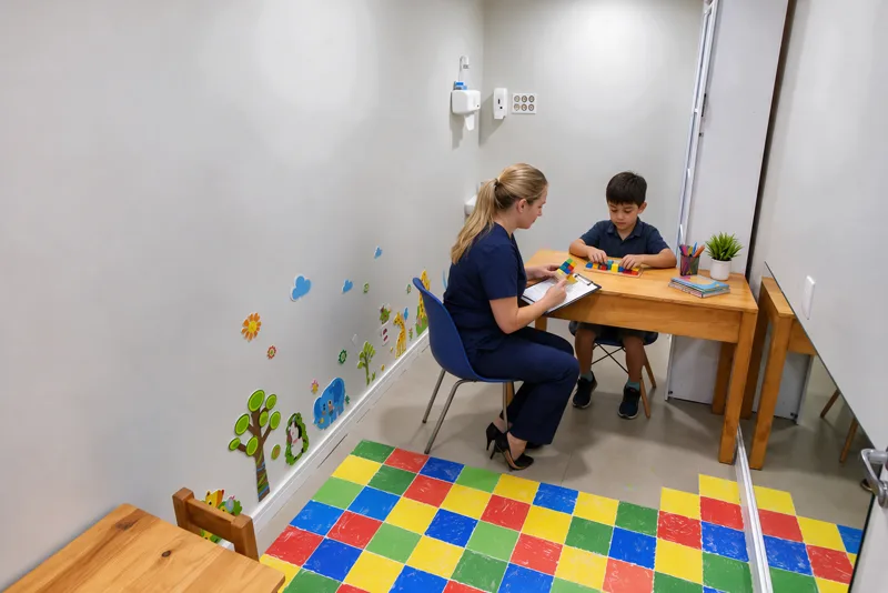 Profissional aplica teste com blocos coloridos em criança durante avaliação neuropsicológica no Instituto Interagir