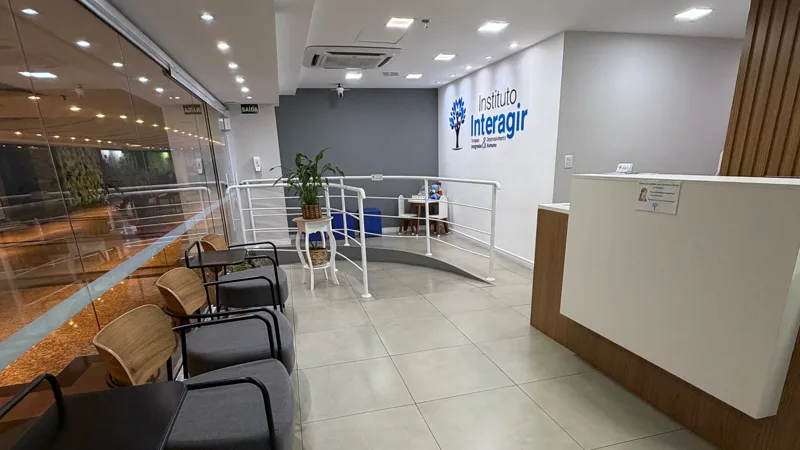 Recepção do Instituto Interagir, com a marca na parede e área de espera
