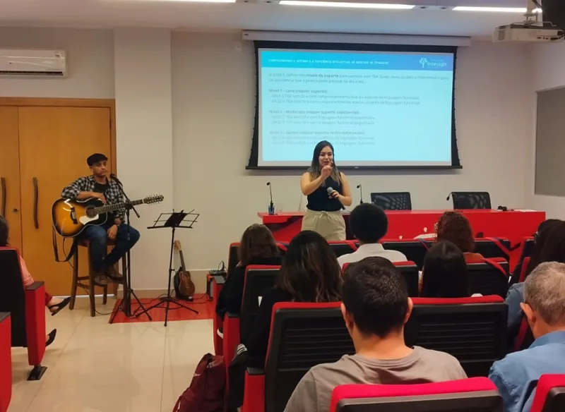 Palestra sobre autismo e deficiência intelectual no mercado de trabalho, com música ao vivo no palco