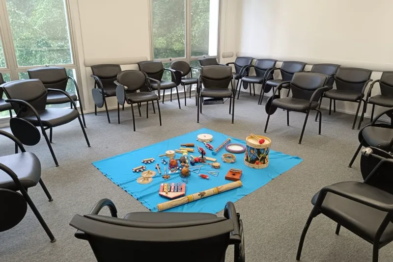 Sala preparada para vivência em empresa, com cadeiras em círculo e instrumentos musicais ao centro